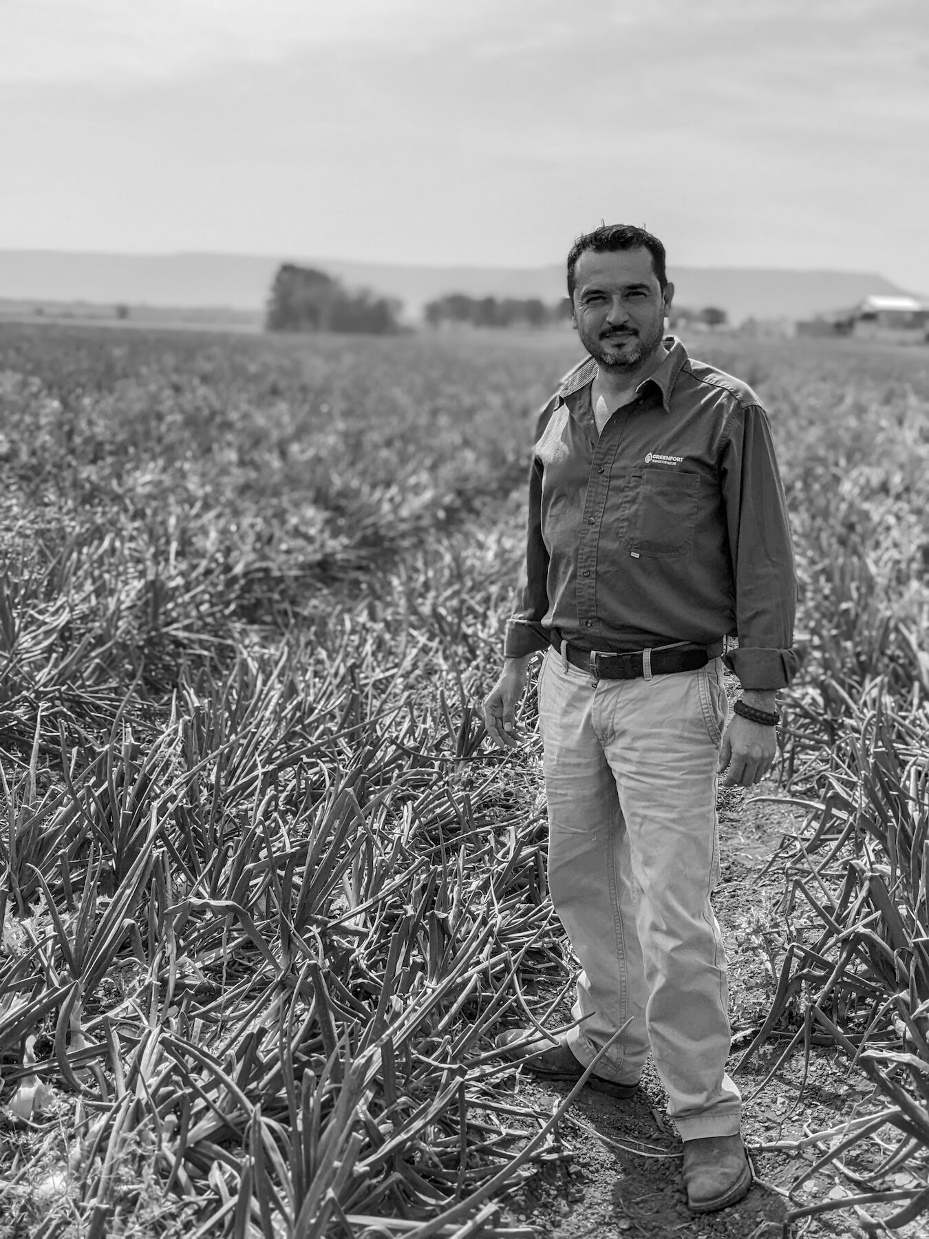 A Granatum agronomist standing in an onion field.